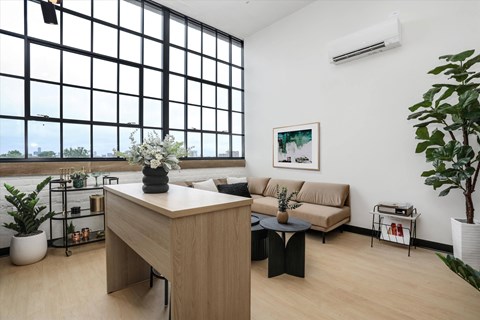 a living room with a couch and a desk and a large window